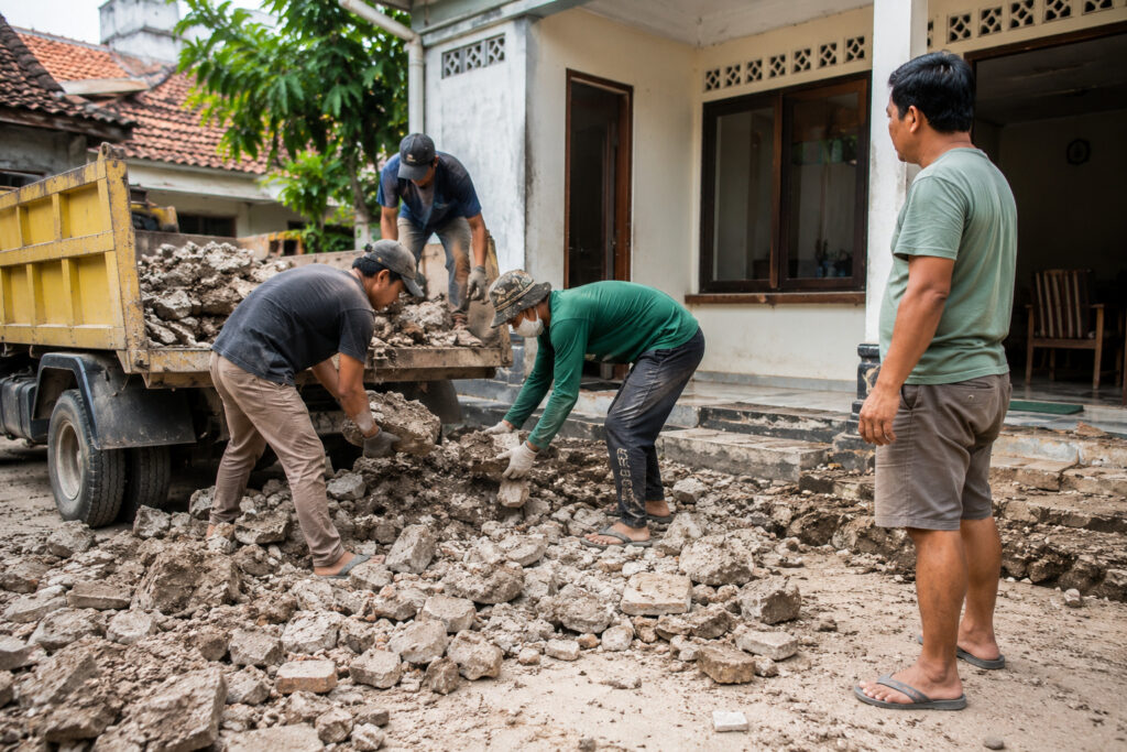 Tim sedang mengangkut puing hasil renovasi rumah di Yogyakarta.